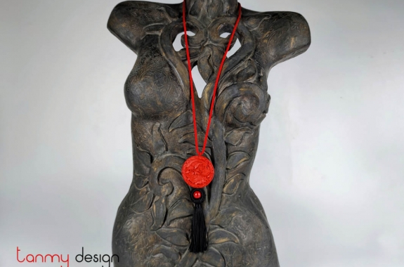 Necklace designed with silk strap with round pendant engraved flower and bird, black tassels